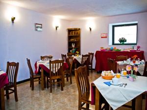 a restaurant with tables and chairs with red table cloth at Posada Playa de Langre in Langre