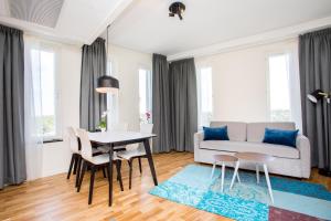 uma sala de estar com uma mesa e cadeiras e um sofá em ApartDirect Älvsjö em Estocolmo