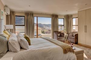 a bedroom with a large bed and a large window at Protea Point in Simonʼs Town