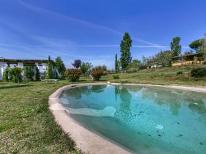 a large swimming pool in a yard with a house at Belvilla by OYO Chalet Graffi in Civitella dʼAgliano
