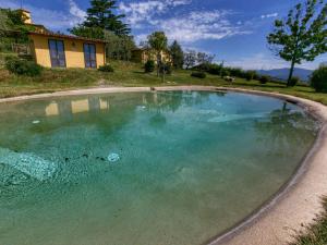 a large pool of water in front of a house at Belvilla by OYO Chalet Graffi in Civitella dʼAgliano