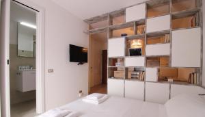 ミラノにあるItalianway-Bligny 39 Studioの白い壁のベッドルーム(ベッド1台、鏡付)