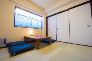 Habitación con mesa, cojines azules y ventana. en GOEN inn Tokyo en Tokio