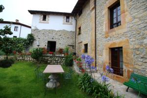 a garden with a table and chairs in front of a building at Posada de Bielva in Bielva
