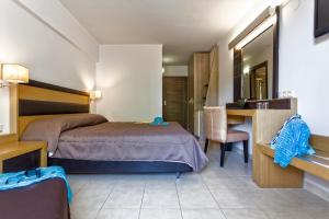 a bedroom with a bed and a desk and a table at Lagomandra Hotel and Spa in Lagomandra