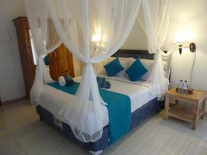 a bedroom with a bed with a canopy at Perdana Homestay Lembongan in Nusa Lembongan