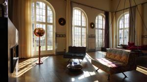 - un salon avec un canapé, des chaises et des fenêtres dans l'établissement Wasserwerk Bad Saarow, à Bad Saarow