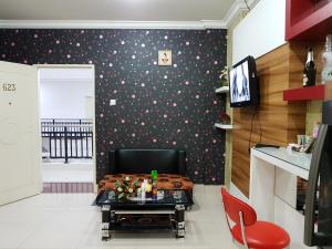 ein Wohnzimmer mit einer schwarzen Wand mit Polka-Punkten in der Unterkunft Apartemen MTC 623 in Manado