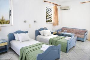 Cette chambre comprend deux lits et un canapé. dans l'établissement Kleanthis Apartments, à Rodakino