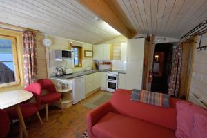a living room with a red couch and a kitchen at Log Cabin in Brecon