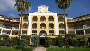 un edificio giallo con una torre dell'orologio sopra di Les Rivages des Issambres a Les Issambres