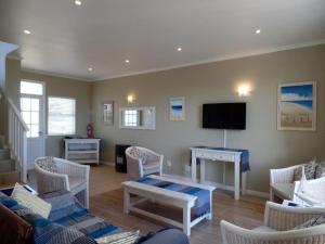 a living room with chairs and a tv and a table at Pinnacle Point Lodge 81 in Mossel Bay