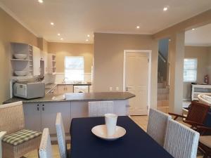 eine Küche und ein Esszimmer mit einem Tisch und Stühlen in der Unterkunft Pinnacle Point Lodge 81 in Mossel Bay