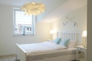 a white bedroom with a bed and a window at Seaside Apartamenty Puck in Puck