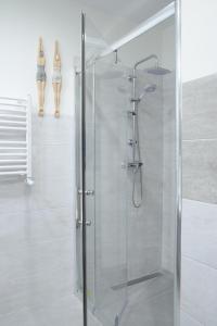 una doccia con una porta in vetro in un bagno di Seaside Apartamenty Puck a Puck