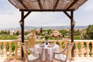 una mesa y sillas en un balcón con vistas en Iraizas Apartamentos, en Otura