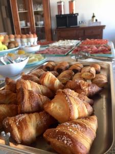un vassoio di croissant e altri prodotti da forno su un tavolo di Hotel Eden a Bardolino