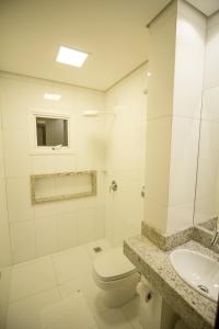 a white bathroom with a toilet and a sink at Hotel Pepita Palace in Sinop