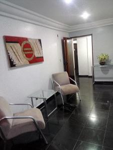 a waiting room with chairs and a glass table at Apartamento Vila Velha-ES in Vila Velha