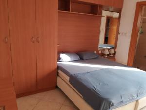 a bedroom with a bed and a wooden cabinet at Holiday Apartments Eilat in Eilat