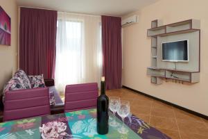 uma sala de estar com uma garrafa de vinho numa mesa em Mars Apartments in Complex Shipka em Sveti Vlas