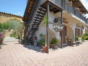 a building with a patio with tables and chairs and a staircase at Agriturismo Due Ganèe in Agrigento
