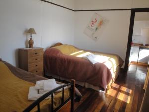 a bedroom with two beds and a dresser with a lamp at The Travelling Chile in Valparaíso