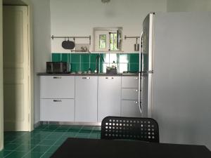 ヴィエトリにあるCasa Marinaのキッチン(緑と白のキャビネット、テーブル付)