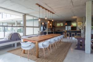 a dining room with a wooden table and white chairs at Red Box Villa in Plettenberg Bay