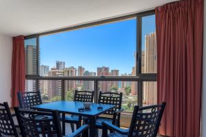 a dining room with a table and chairs and a large window at Gemelos 20 - Beninter All Inclusive in Benidorm