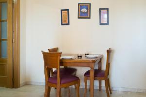 una mesa de madera con 2 sillas y una mesa con 2 platos en Gemelos 20 - Beninter All Inclusive, en Benidorm