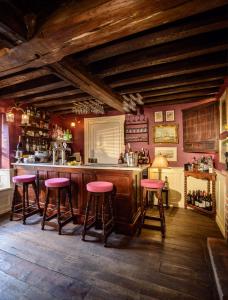 a kitchen with a bar with pink stools in it at Ye Spotted Dogge in Portsmouth