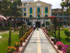 Ein Mann, der vor einem Gebäude mit Blumen geht. in der Unterkunft Kathmandu Guest House by KGH Group in Kathmandu