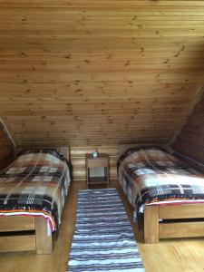 zwei Betten in einem Zimmer mit Holzdecken in der Unterkunft Kazkova khatynka in Bushtyno