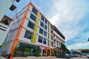 an orange and white building on a city street at Sabuy Best Hotel Phayao in Phayao