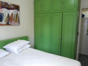 1 dormitorio con armarios verdes y 1 cama blanca en Saint Martin Flat Residence, en Fortaleza