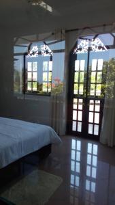 una camera da letto con due finestre e un letto in esso di Sagarika Beach Hotel a Moragalla