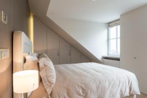 a bedroom with a white bed and a window at Relais Louvigny in Luxembourg