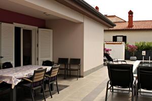 a patio with a table and chairs on a balcony at Holiday house Veli vrh in Pula