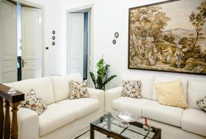 un soggiorno con divano bianco e un dipinto sul muro di BellAqua a Catania