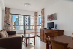 sala de estar con sofá y TV en Gemelos 4 - Beninter All Inclusive, en Benidorm