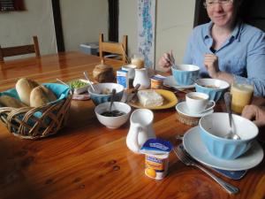 瓦爾帕萊索的住宿－The Travelling Chile，坐在木桌旁吃碗食物的女人