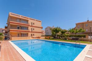 a swimming pool in front of a building at Apartaments Fincasol in L'Estartit