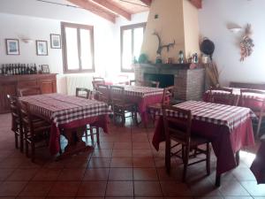 a restaurant with tables and chairs and a fireplace at Agriturismo Rio Ricco in Busana