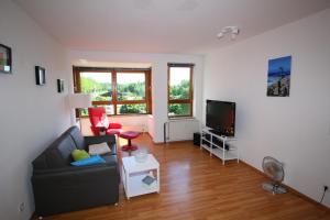sala de estar con sofá y TV en Wohnen auf Zeit am Golfplatz Motzen, en Motzen