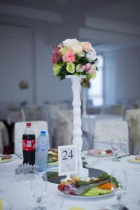 a table with a vase with a flower on it at Hotel Emi in Strumica