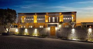 a building with a stone wall in front of it at Eritrina Alacati in Alacati