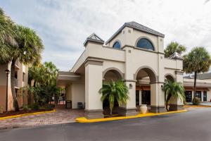 a church with palm trees in front of a street at Days Inn & Suites by Wyndham Orlando Airport in Orlando