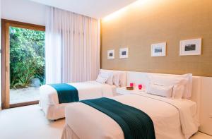 2 camas en una habitación de hotel con ventana en Pool Villas Tivoli Ecoresort en Praia do Forte