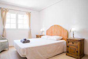 ein Schlafzimmer mit einem Bett und einem Stuhl und einem Fenster in der Unterkunft Villa Veronica in Corralejo + 20 Fotos